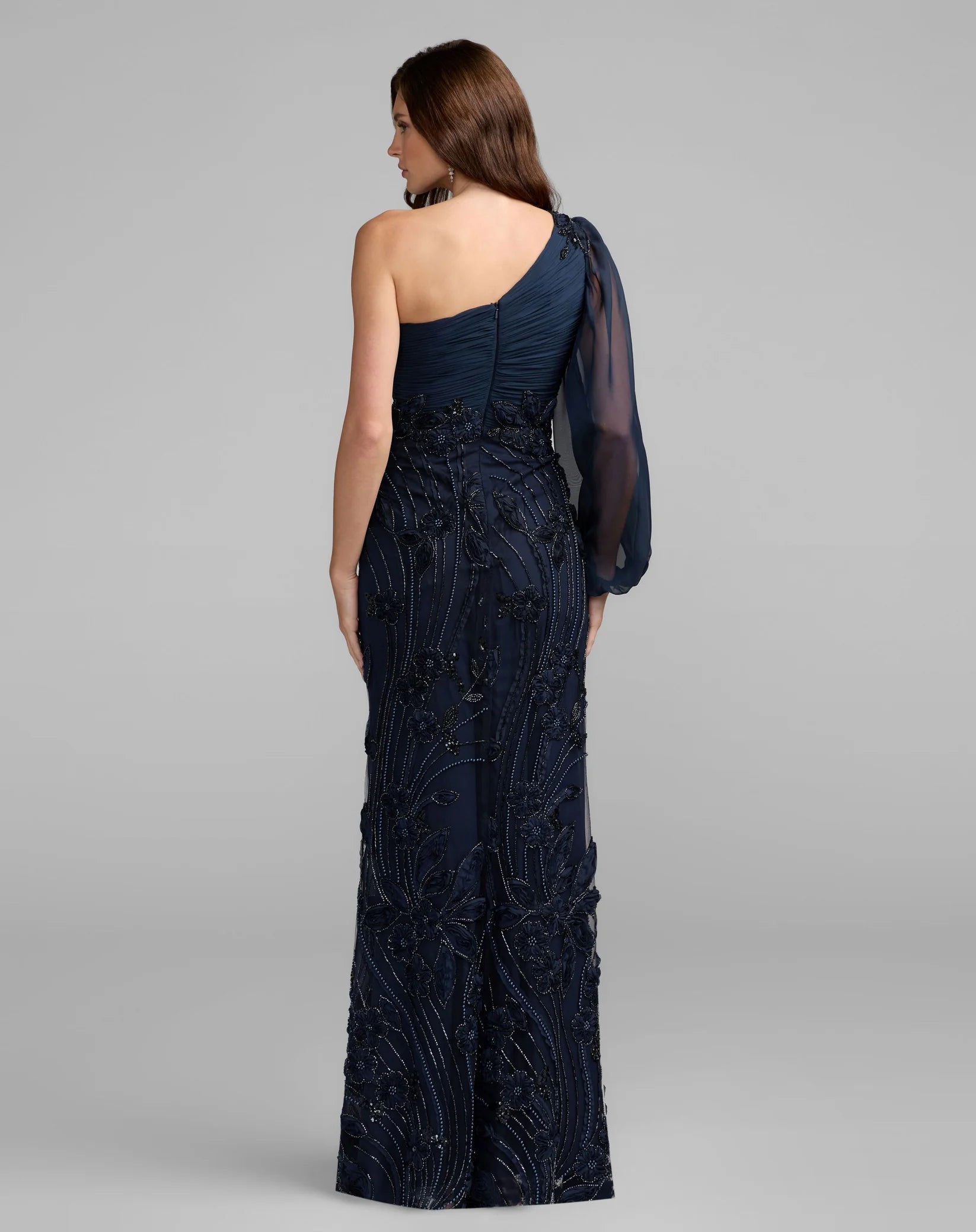 Navy one-shoulder evening gown on a model against a gray background