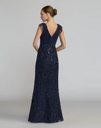 Full-length back view of a model wearing a midnight chiffon and mesh formal gown.