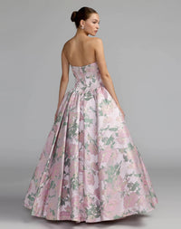 Woman wearing a strapless floral gown on a gray background