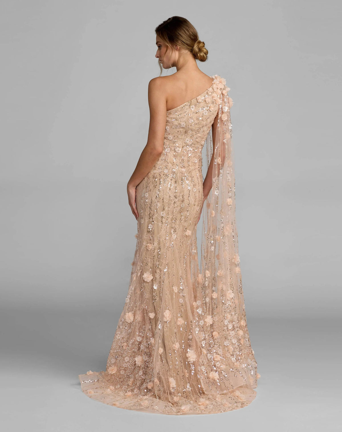 Back view of the blush mermaid gown, showcasing the sheer illusion back and flared silhouette.