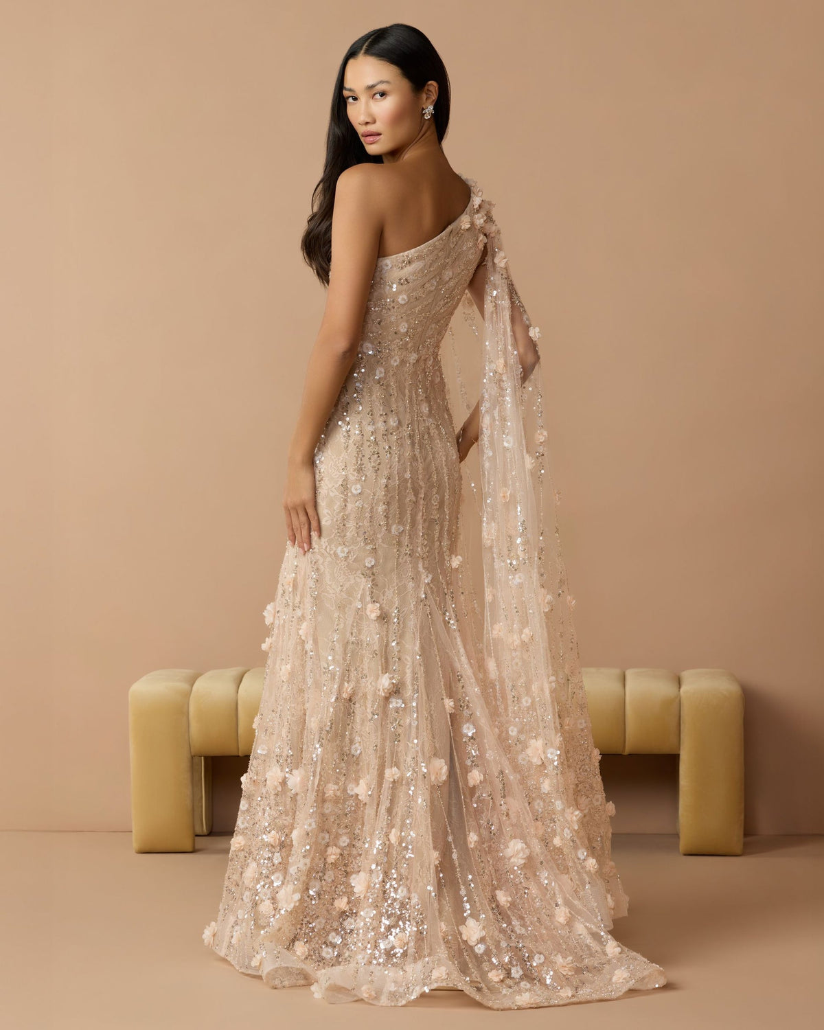 Lifestyle back view of a model in the blush gown, highlighting the illusion back and reinforced hem.