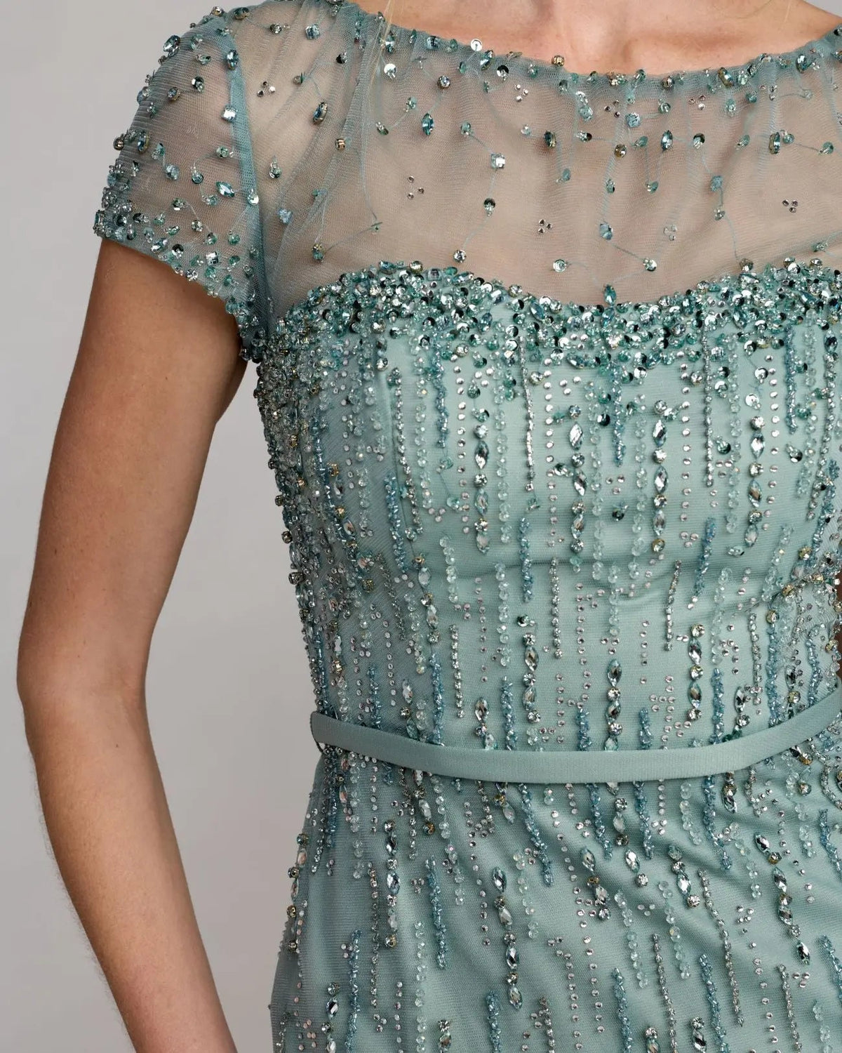 Close-up detail of the illusion boat neckline and cascading rhinestone and crystal embellishments.