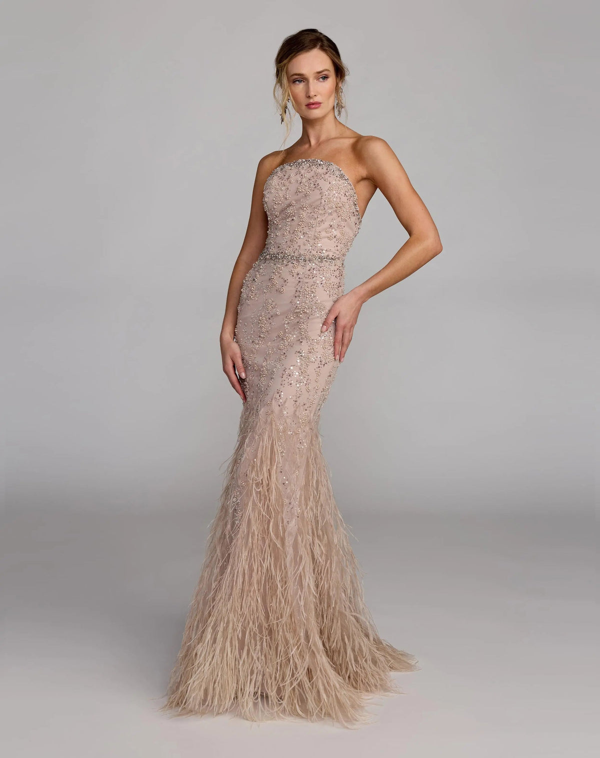 77103-Champagne-AB.jpg: Full-length front view of the strapless Champagne evening gown featuring pearl embellishments and a dramatic feathered hem.