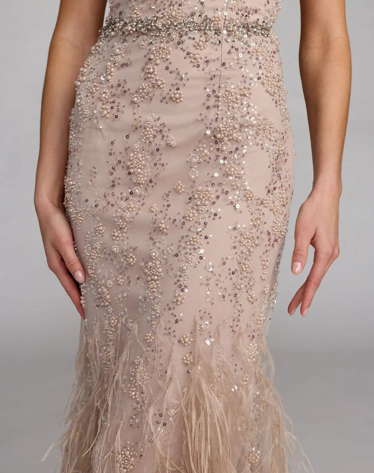 77103-Champagne-BK.jpg: Back view of the Champagne net gown showcasing the uniform sequin pattern and the volume of the feathered trim.