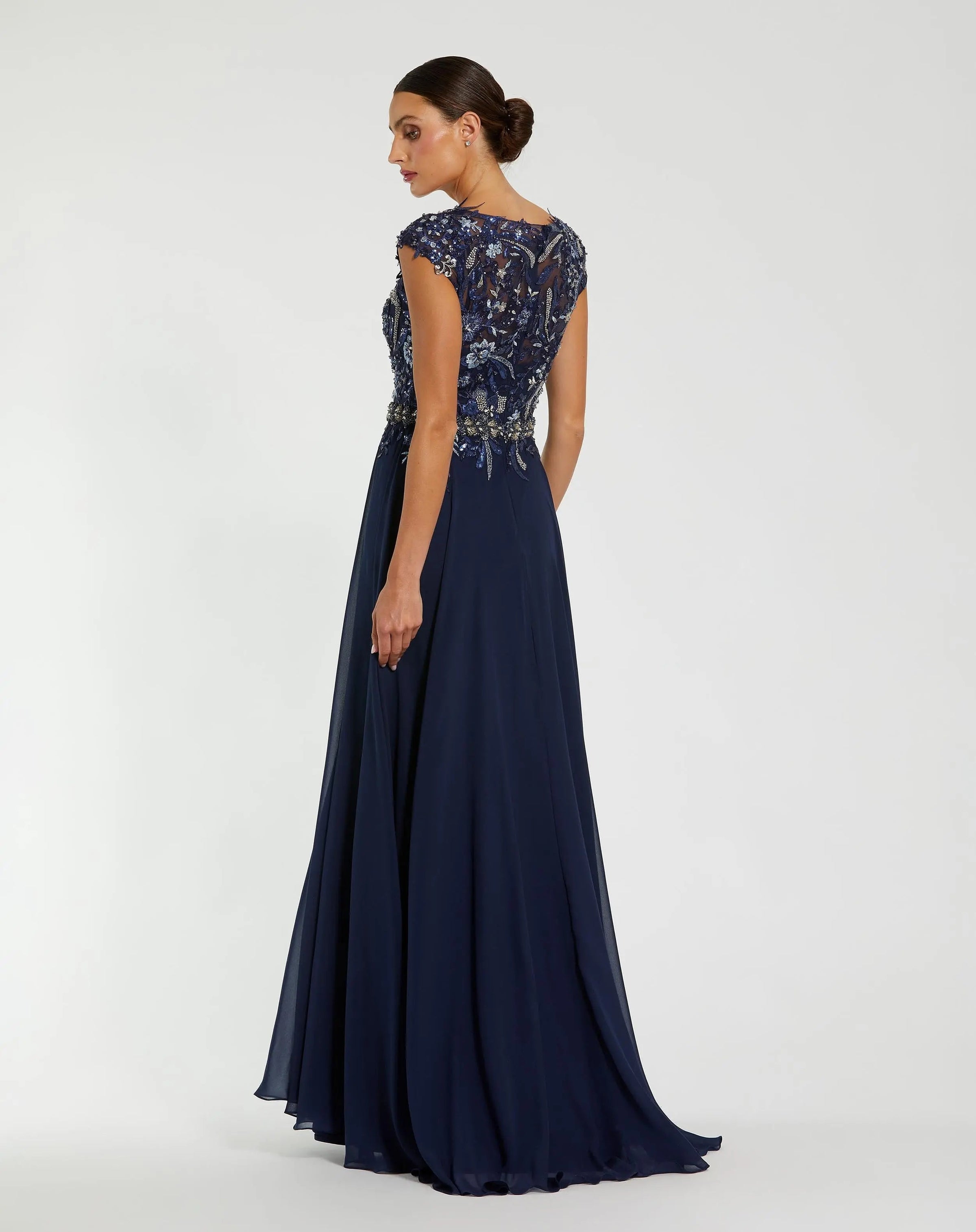 Navy evening gown with intricate top design on a white background