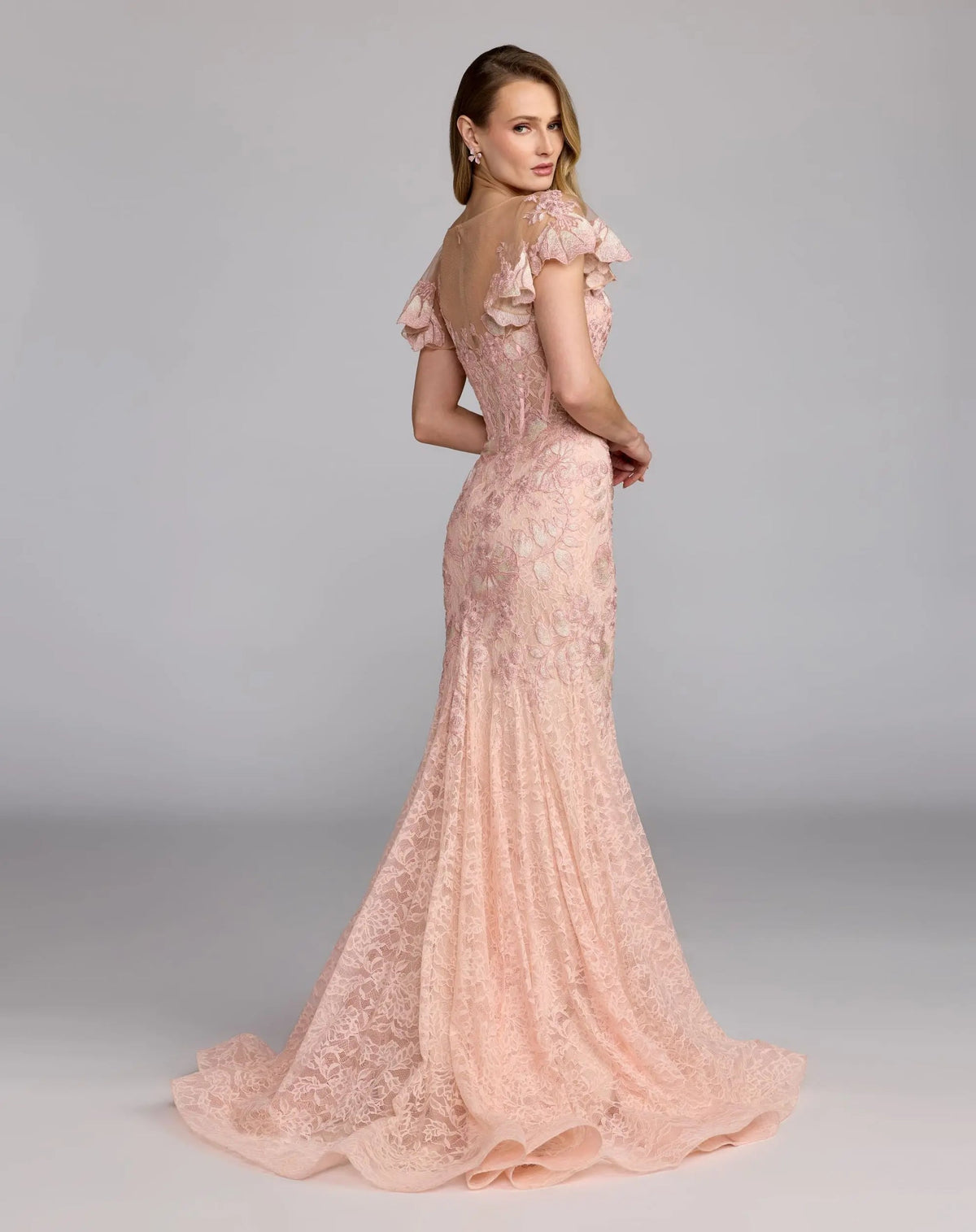 Back view of the blush mermaid gown, showcasing the sheer illusion back and flared silhouette.