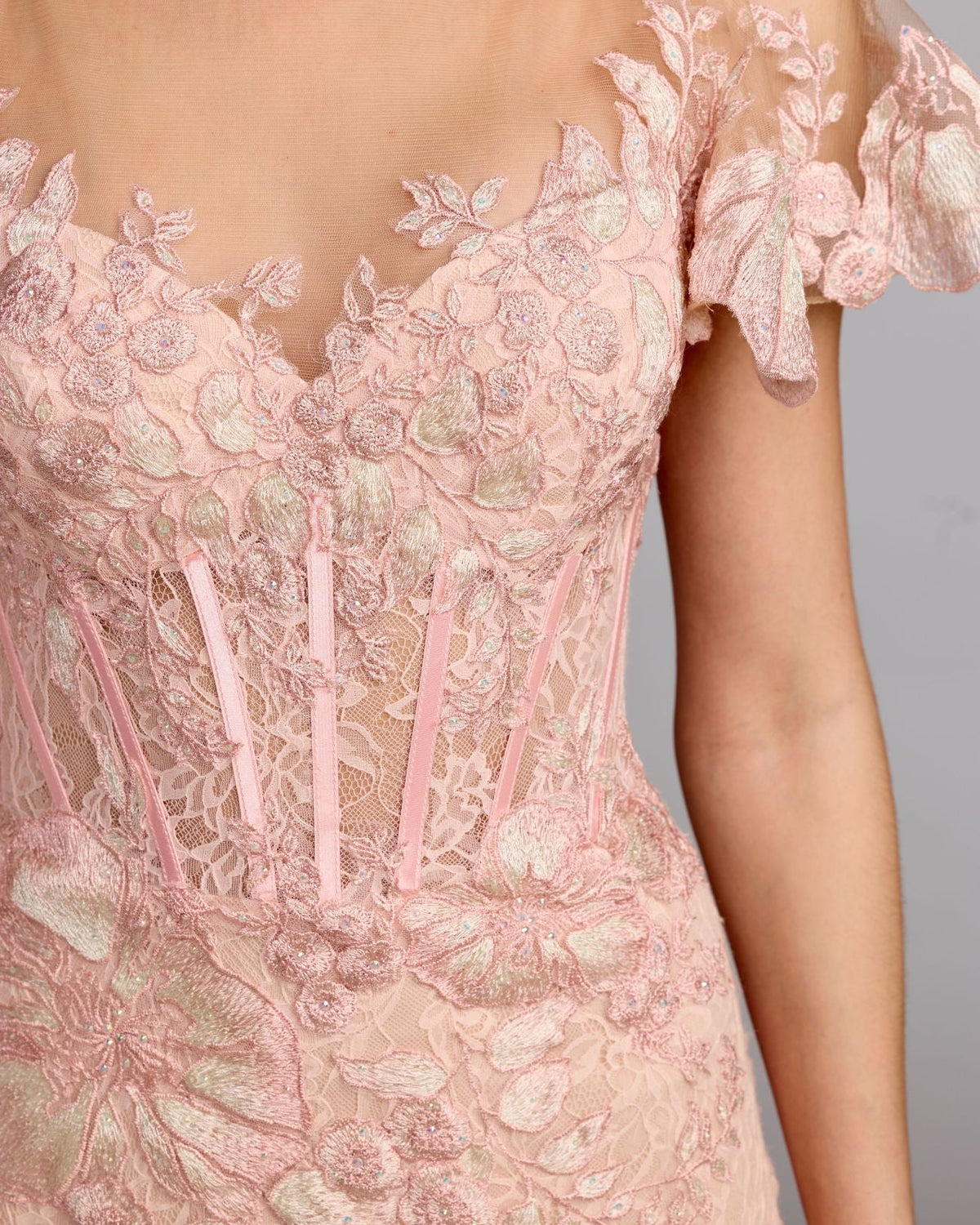 Close-up of the bustier bodice and floral embroidery detail on the blush gown.