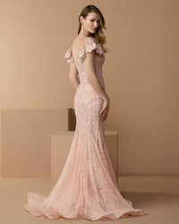 Back view of the blush mermaid gown, showcasing the sheer illusion back and flared silhouette.