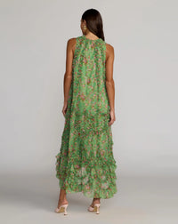 Woman wearing a green floral dress against a plain background