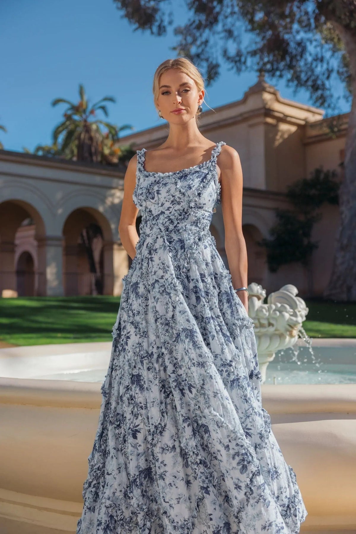 Editorial shot of model wearing blue floral ruffle garden party dress