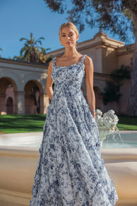 Editorial shot of model wearing blue floral ruffle garden party dress