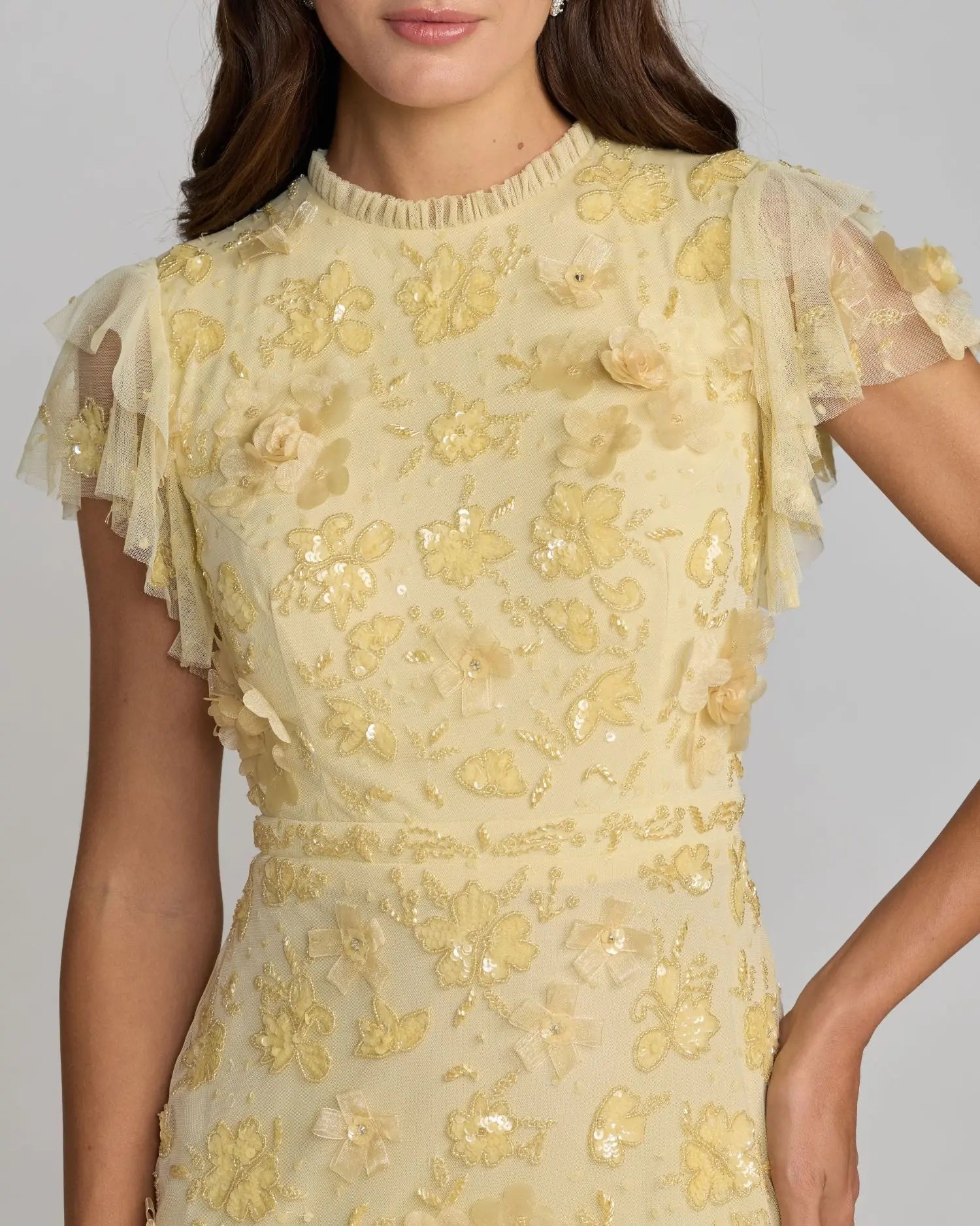 Yellow floral embroidered dress on a plain background