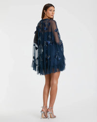 Woman wearing a navy blue dress with floral embroidery on a white background