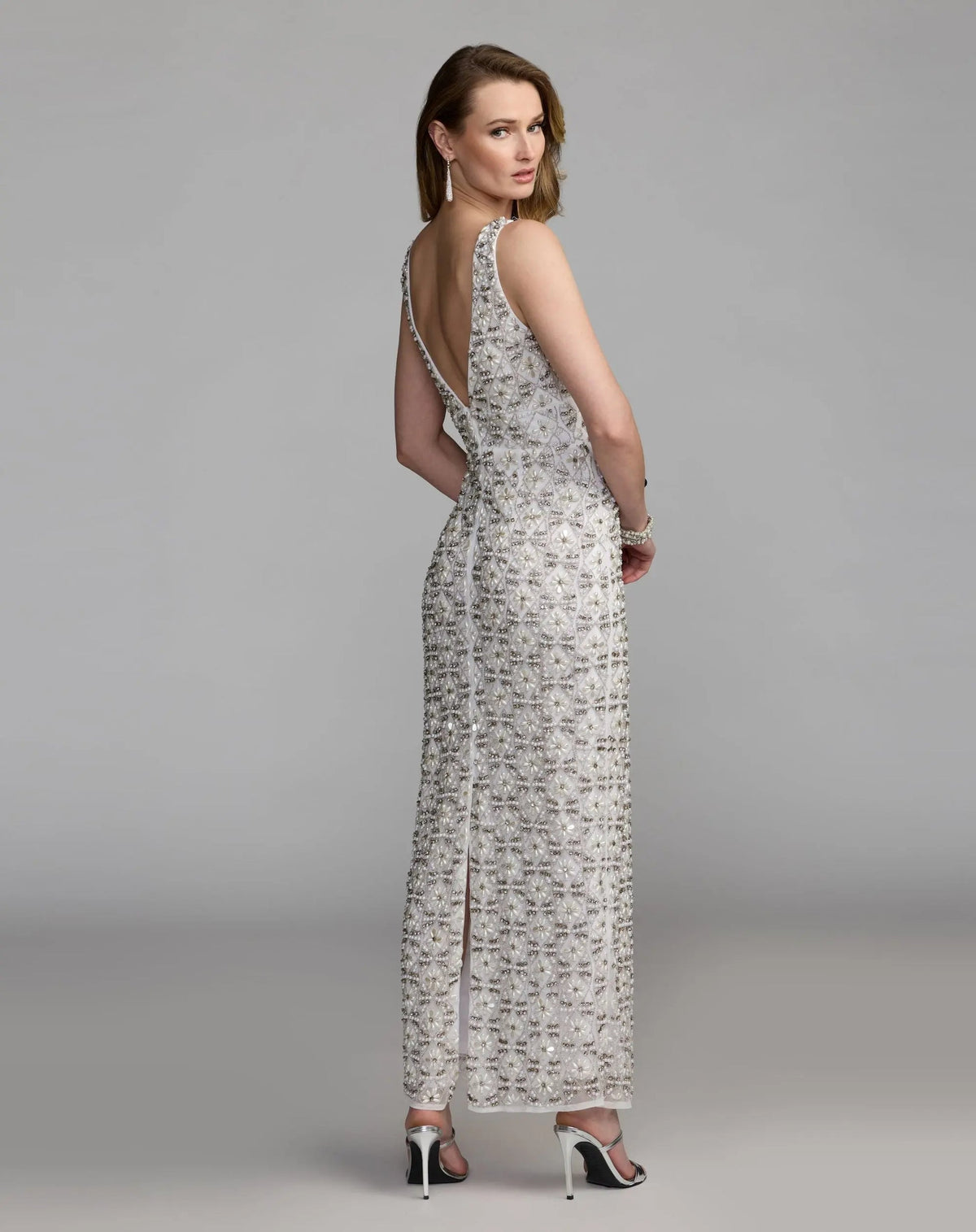 Back view of the Ivory formal dress highlighting the elegant V-back design, matching lattice work, and bottom back slit.