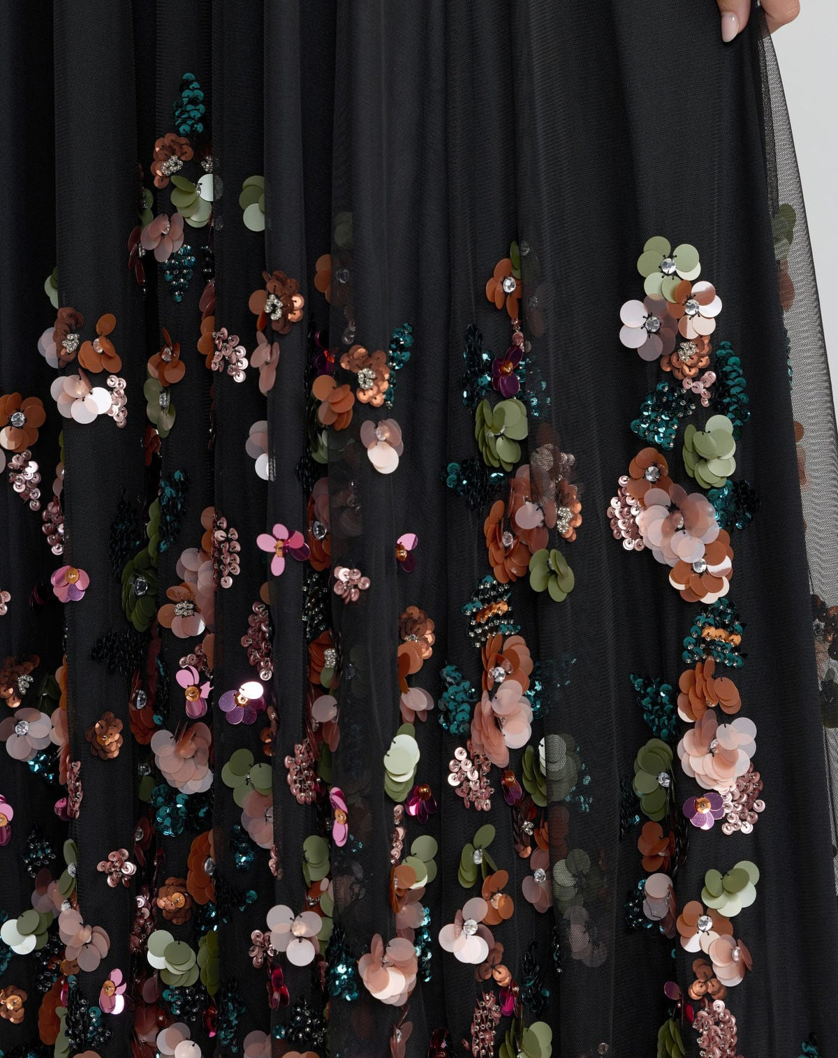 Close up of delicate floral beadwork and embroidery on black dress