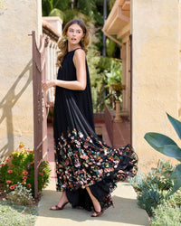 Side view of model in sleeveless black high neck gown