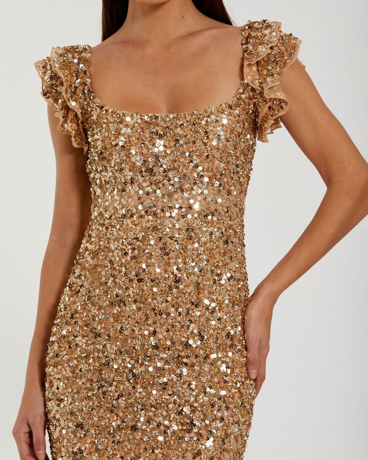 Close-up view of the bodice and flutter cap sleeves on a gold sequin gown.