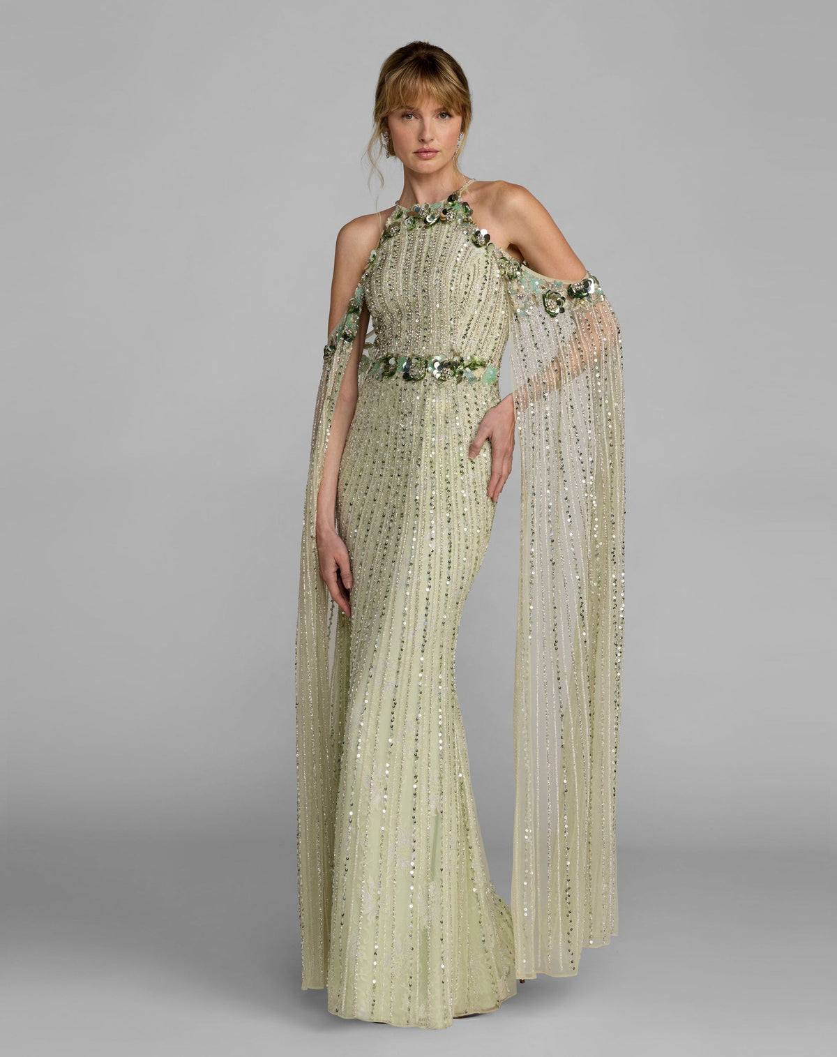 Full-length studio shot of a model wearing the seafoam halter column gown with 3D floral embellishments.