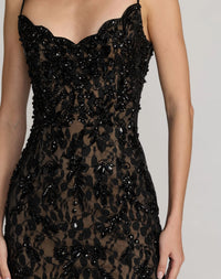 Black lace dress with bead detailing on a neutral background