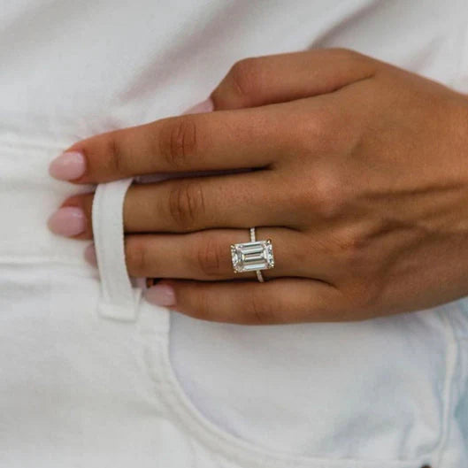 Hand model lifestyle shot wearing the 5 carat emerald cut celebrity style engagement ring inspired by Nicola Peltz Beckham on a delicate diamond pavé band.