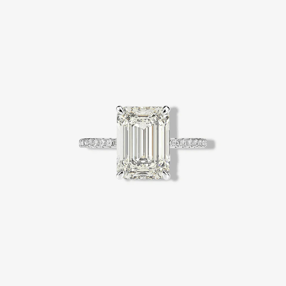 Front studio macro view of a Margalit Rings 5 carat emerald cut diamond simulant engagement ring with classic prongs and a brilliant micro pavé sterling silver band.