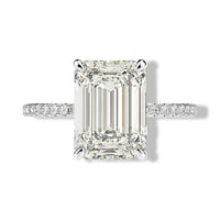 Clean top-down isolated product image of a high-clarity 5 carat emerald cut timeless gemstone promise and cocktail ring on a pavé sterling silver setting.