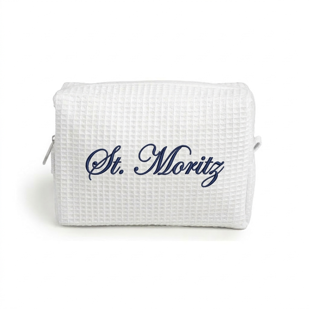 White waffle weave makeup bag with white 'St Moritz' embroidery.
