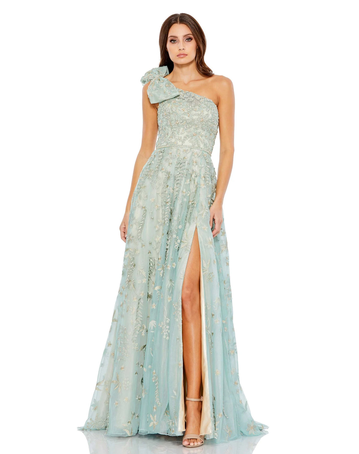 This incredible sage green gown is made from shimmery, botanical-embroidered tulle with with a rhinestone trim at the waist and topped with a feminine full bow at the single shoulder. It’s glamorous, romantic—and with a high leg slit—flirty, too. This gown is perfect for wedding guests and Summer parties!