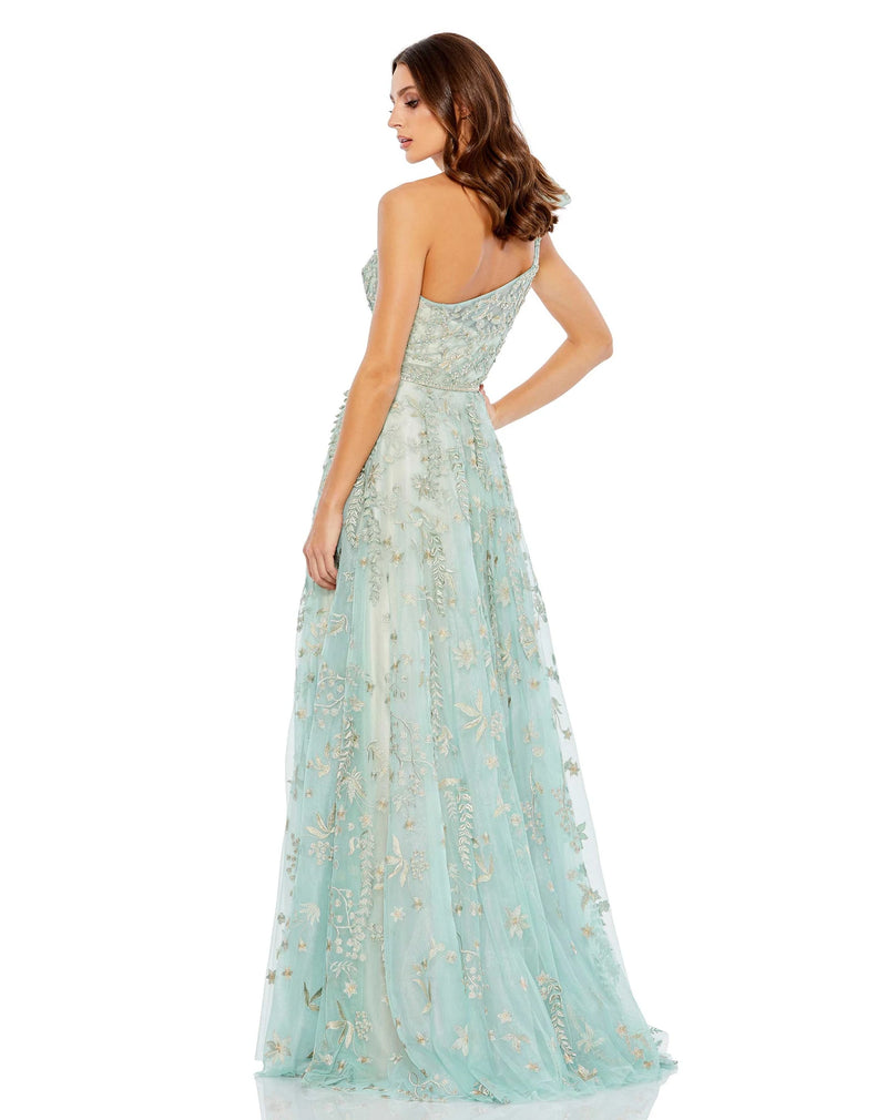 This incredible sage green gown is made from shimmery, botanical-embroidered tulle with with a rhinestone trim at the waist and topped with a feminine full bow at the single shoulder. It’s glamorous, romantic—and with a high leg slit—flirty, too. This gown is perfect for wedding guests and Summer parties back view