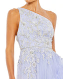 Made in a pretty shade of periwinkle blue in tulle with a lining to match, the unique gown is styled with a one-shoulder topline, botanical embroidery, glittering rhinestone accents, and ruffle trim. The dress trades a more traditional slit for a dramatic asymmetrical cut that highlights lots of leg close up