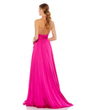 This elegant, floor-length, Mac Duggal, hot pink, magenta evening dress is a beautiful, Grecian inspired evening gown. Crafted with satin charmeuse, this halter gown features a plunging v-neckline, sexy open back, a self-tie belted waist, and a floor-length box pleated skirt with a thigh-high slit and sweeping train. This gown is perfect for proms, black-tie affairs, weddings and special events back view