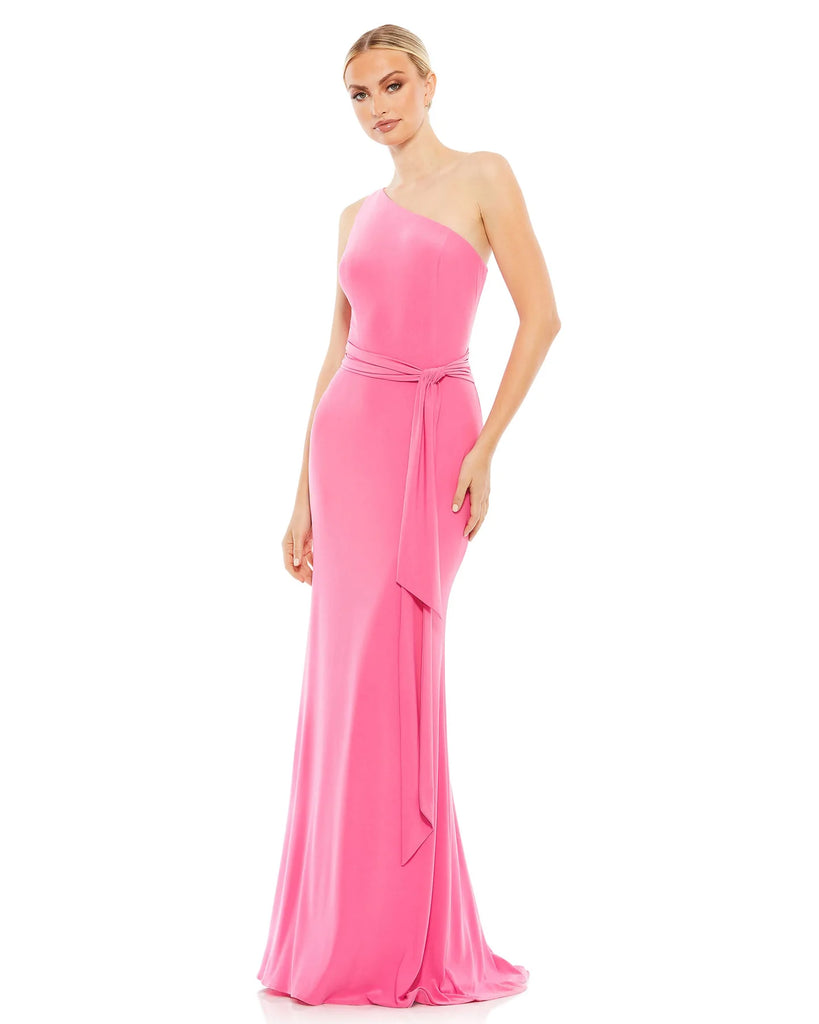This youthful and feminine floor-length, jersey candy pink evening dress with one-shoulder detail, a cinched waist and a beautiful bodycon skirt flowing down to a little train and trumpet detail at the back is a gorgeous choice for proms, black-tie affairs, weddings and special events!