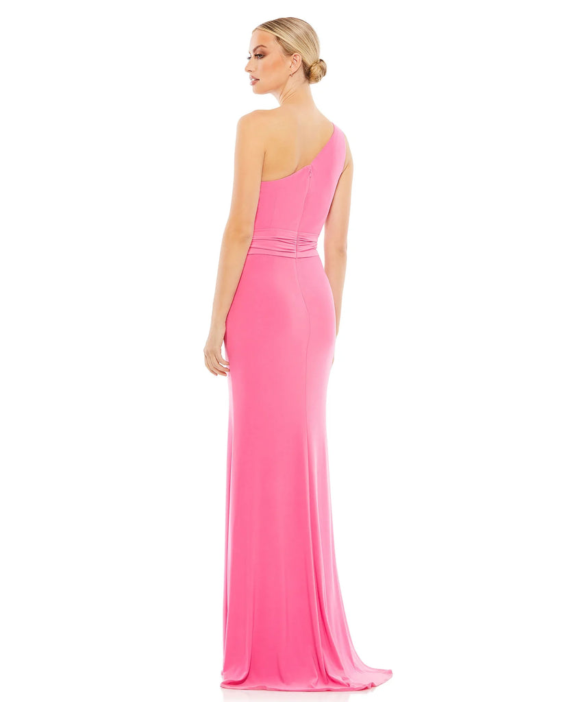 This youthful and feminine floor-length, jersey candy pink evening dress with one-shoulder detail, a cinched waist and a beautiful bodycon skirt flowing down to a little train and trumpet detail at the back is a gorgeous choice for proms, black-tie affairs, weddings and special events back view