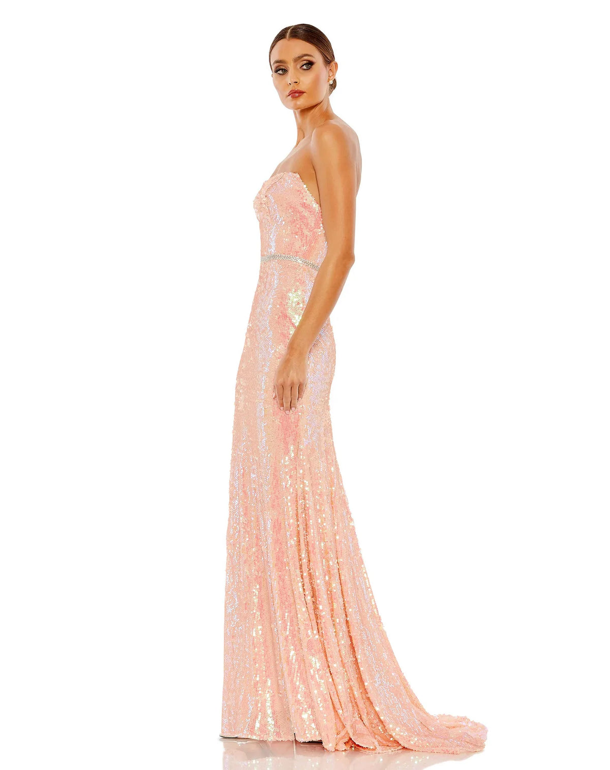 This elegant strapless, coral pink toned, floor length, fitted, formal dress is picture perfect. With an elongating column style and sequinned fabric with a gorgeous crystal belt to cinch in the waist, is finished with a glamorous sweeping train. This gown is perfect for wedding guests, special occasions and proms side view