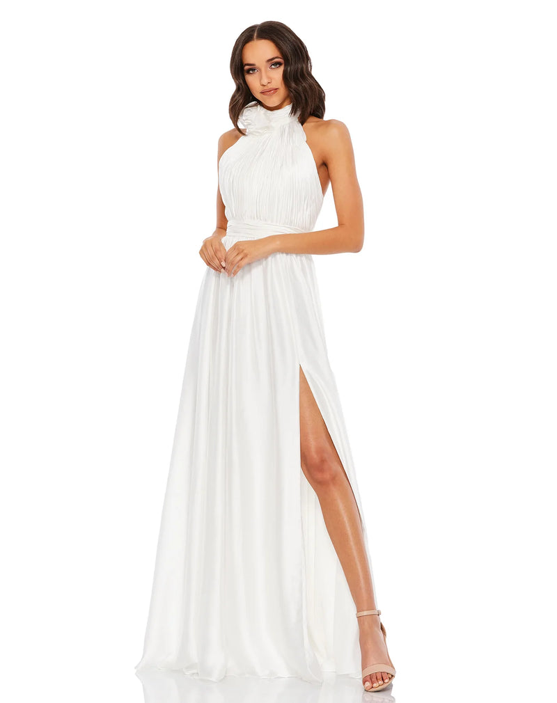 This elegant white floor length, halterneck, sleeveless evening gown is perfect for brides and brides to be! Crafted with delicate chiffon, this dress features a ruched bodice and waistband, together with an open back, and a rosette neckline. The flowing  floor-length skirt features a thigh-high slit for a dramatic finish!