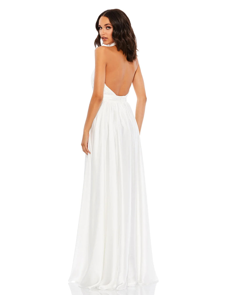 This elegant white floor length, halterneck, sleeveless evening gown is perfect for brides and brides to be! Crafted with delicate chiffon, this dress features a ruched bodice and waistband, together with an open back, and a rosette neckline. The flowing  floor-length skirt features a thigh-high slit for a dramatic finish back view