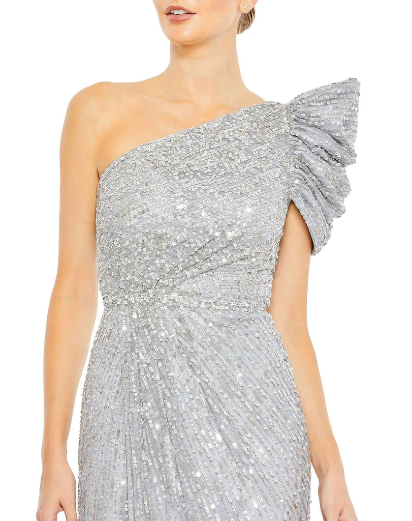 This beautiful silver sequin, one-shoulder, asymmetric floor-length, evening gown with a beautiful cinched waist and puff detail on the shoulder is an elegant gown for special occasions and events with one thigh high split and an elegant form-fitting fit close up