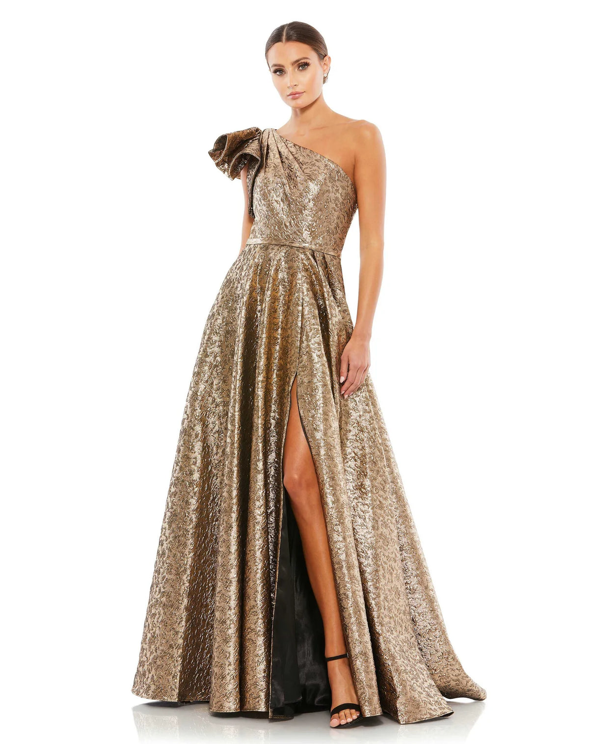 This stunningly elegant, one-shoulder metallic brocade antique gold, ball gown is a truly show-stopping evening dress accented with asymmetric chest detail, bow-detail on the shoulder, a cinched in waist and a beautiful full skirt with a thigh high split. This A line ball gown is perfect for proms, black-tie affairs, weddings and special events front view